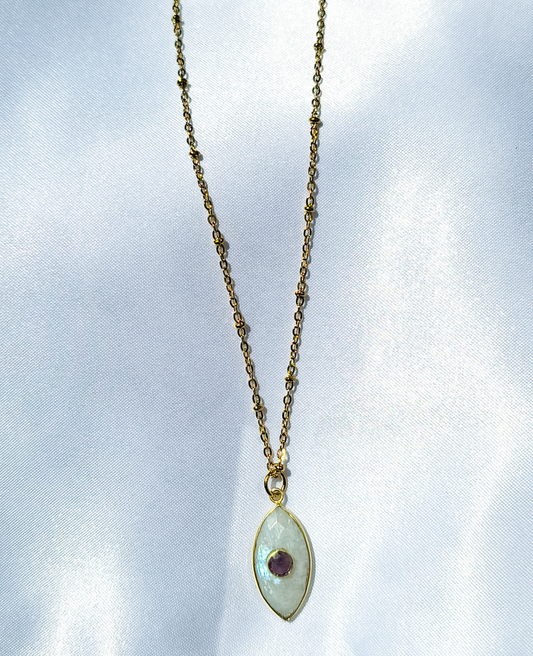 A gold chain with a big oval shaped moonstone pendant with an small amethyst stone in the middle of the pendant.